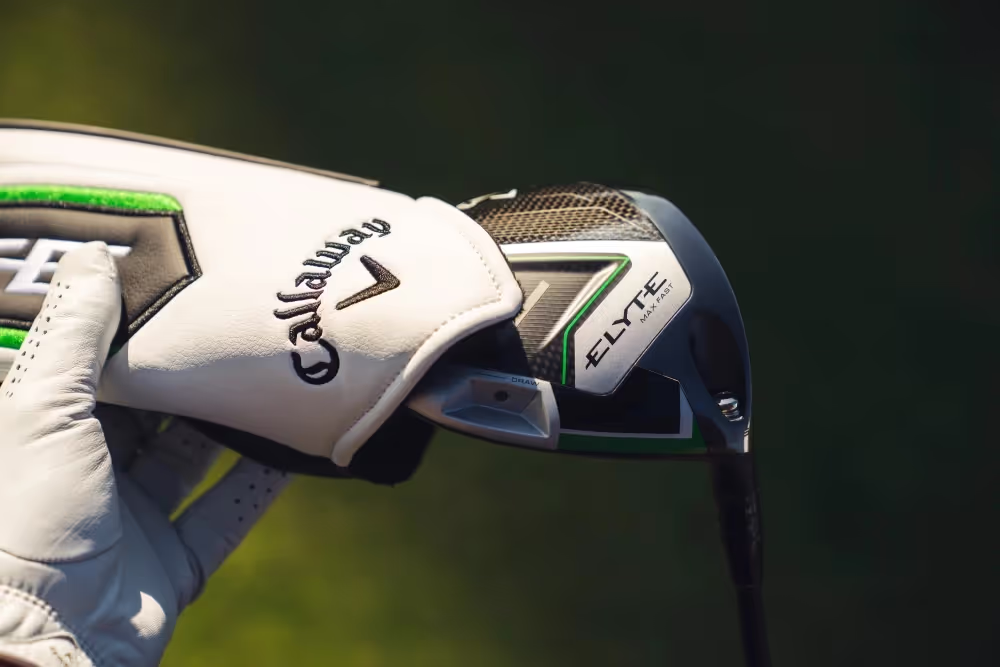 Golfer removing the headcover from the Callaway Elyte driver on the course. 