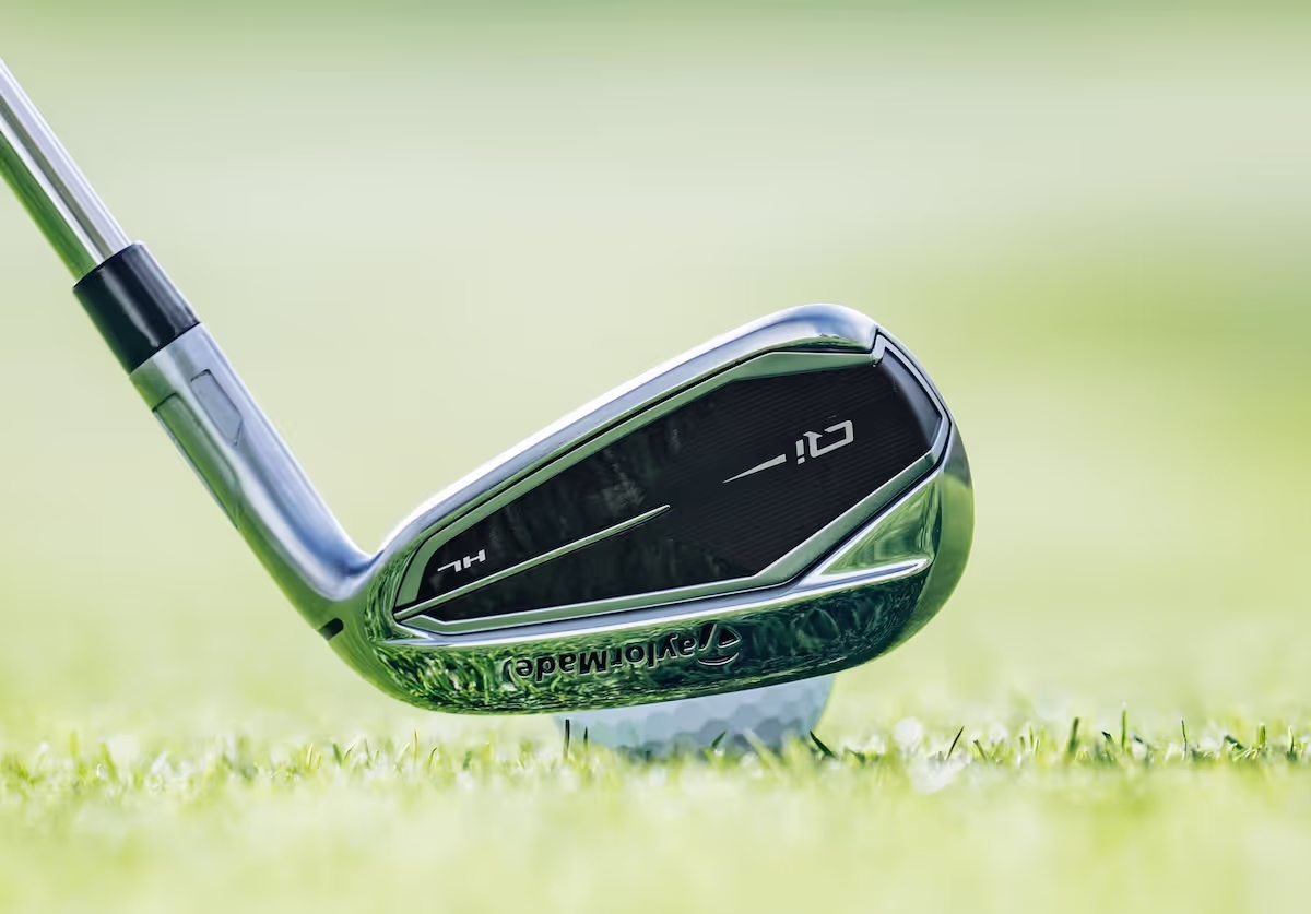 Close-up view of a TaylorMade Qi iron in position to hit the golf ball on the fairway.