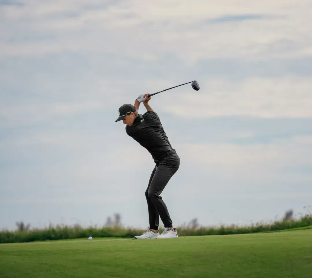 Man swinging GT1 driver on the golf course, captured mid-swing 