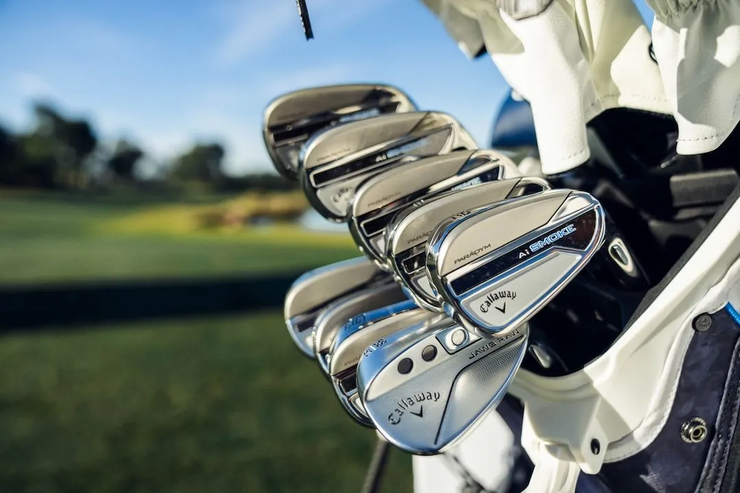 Golf bag full of Callaway Paradym Ai Smoke irons, sitting on the course. 
