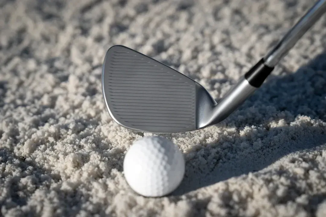 PING BunkR Sand wedge lined up to hit a bunker shot, highlighting its design for easy escapes. 