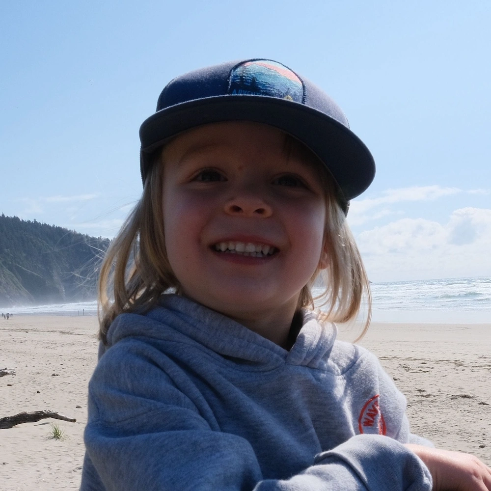 Smiling homeschool kid on the beach learning with family