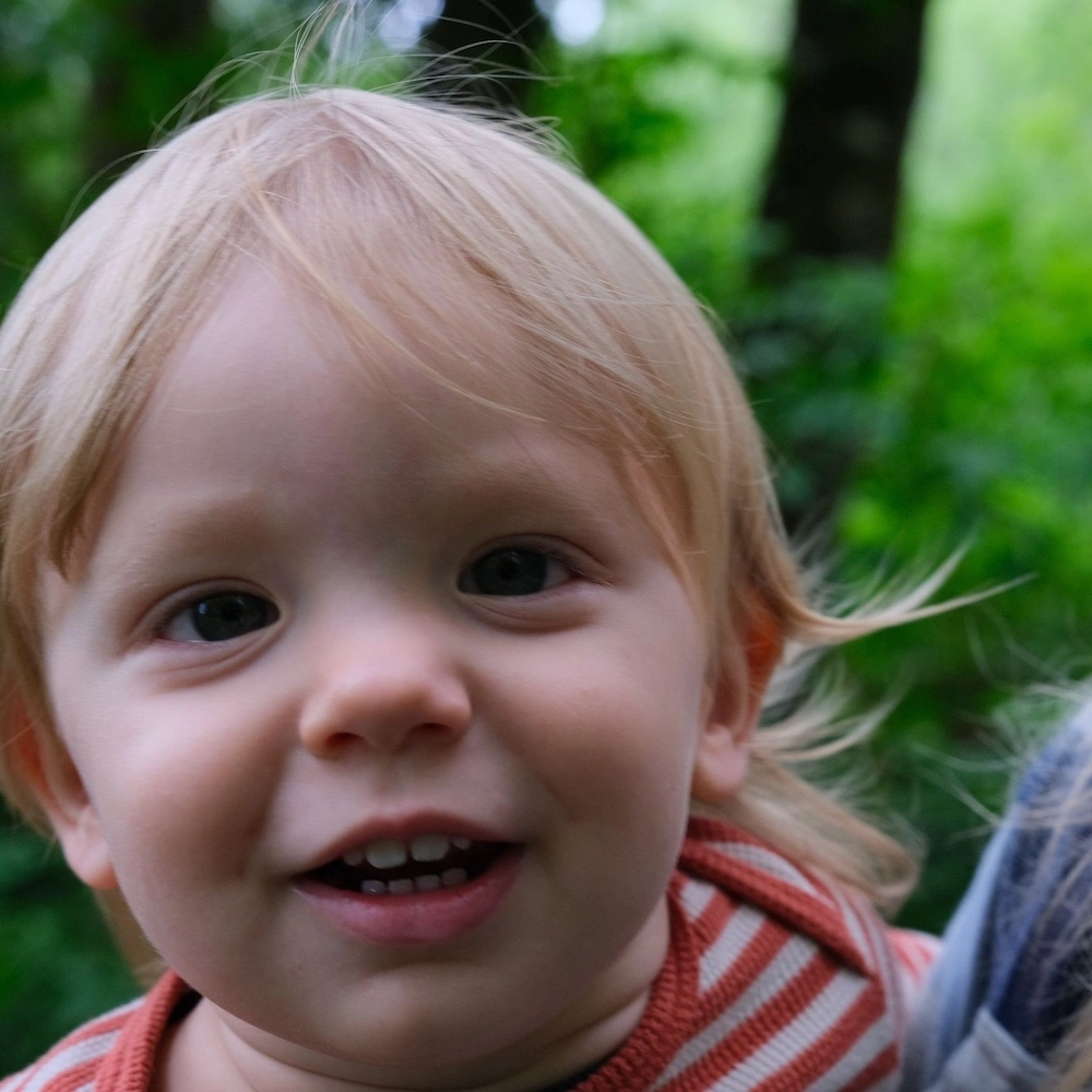 Smiling toddler excited to be a part of family homeschooling