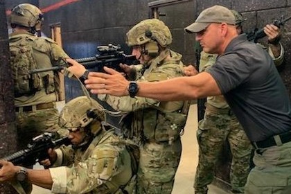 Military personnel training with firearms in tactical indoor shooting range