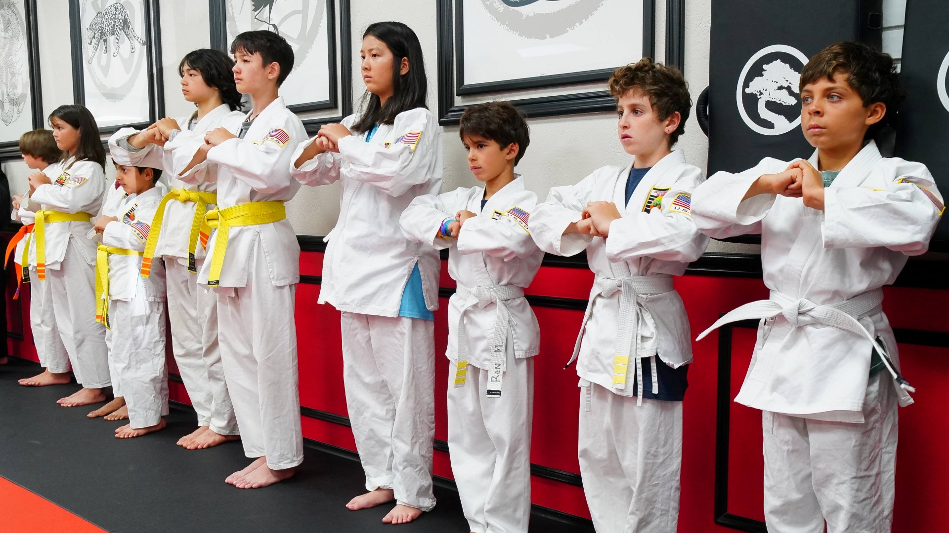 Beginner Karate students stand in a tight row, ready for class to begin.