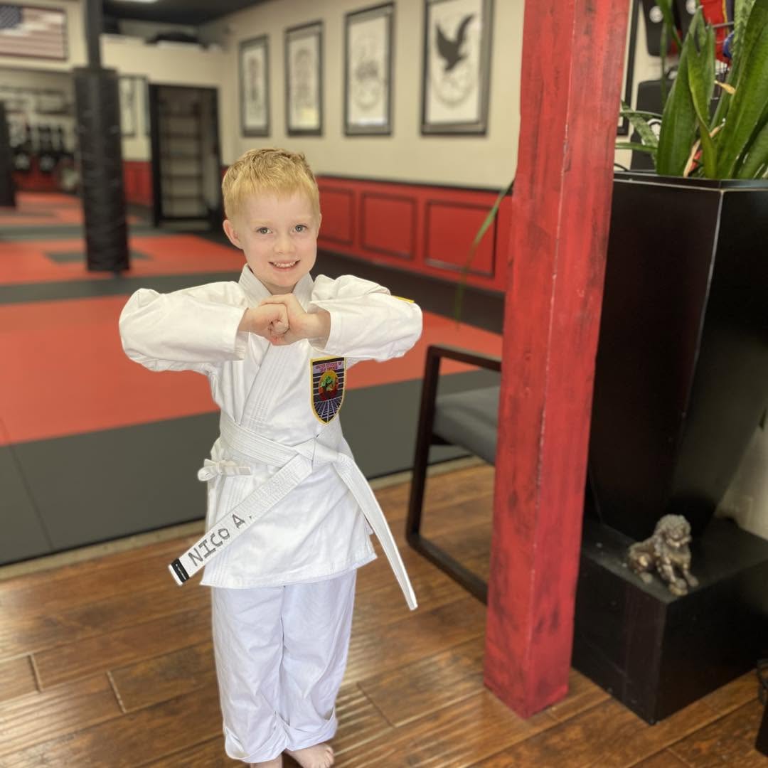 A young karate student showing off their focus by standing at attention.