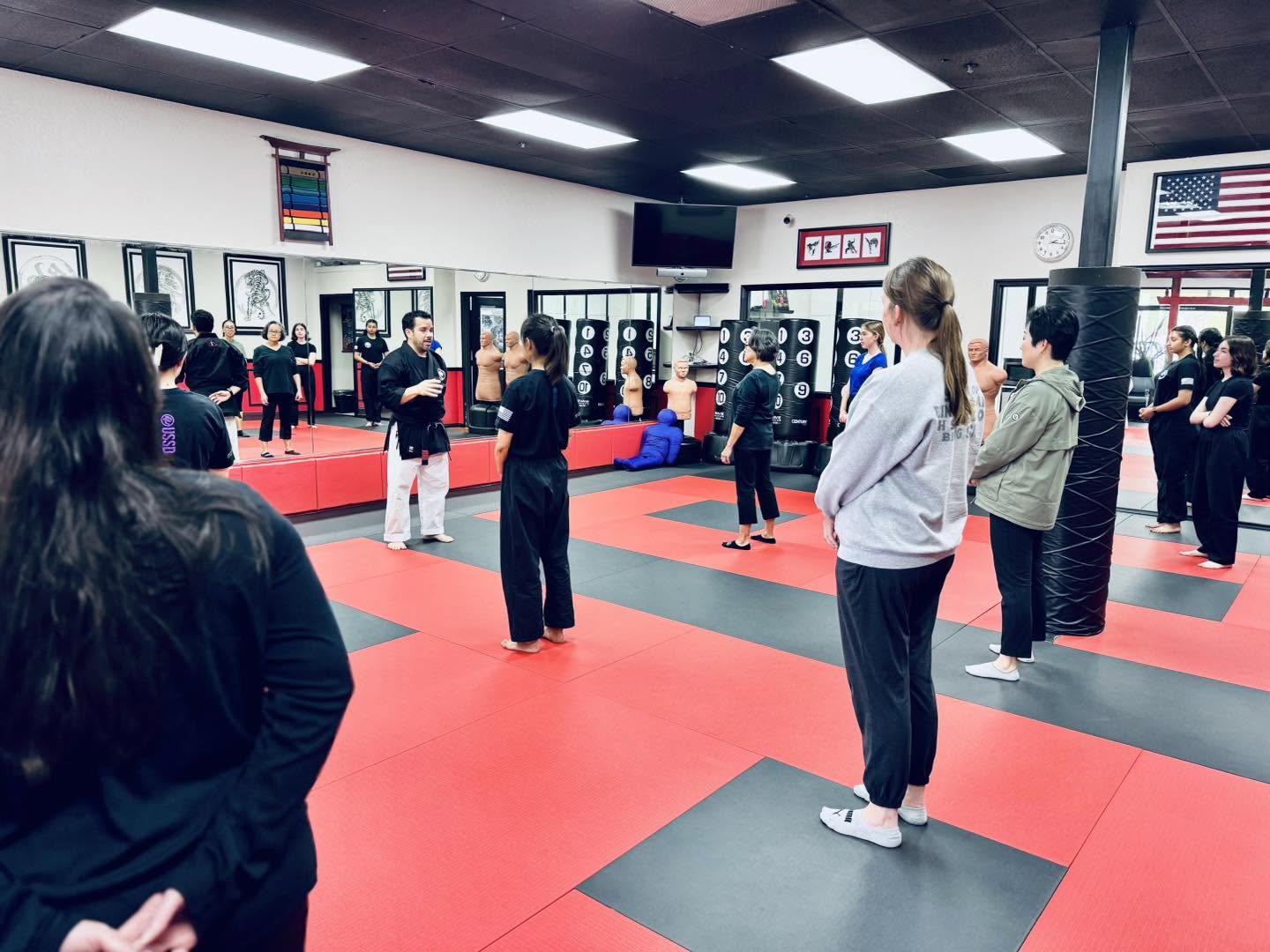 A group of adult self defense students listening during a Women's Self Defense class at USSD Irvine Woodbridge
