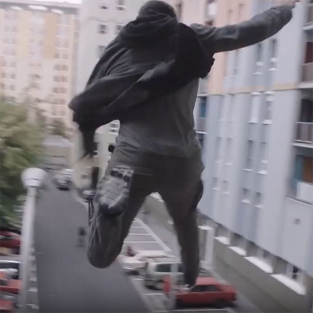 A freeze frame from the film The Spy Who Dumped Me of the actor Justin Theroux jumping from a balcony in an urban setting