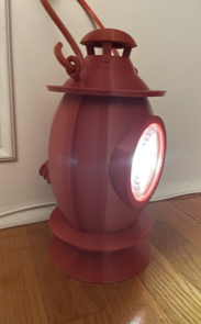 Red, 3D-printed Lantern with light on, viewed from the side