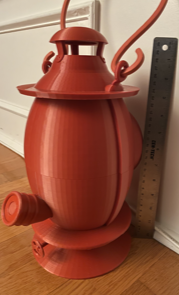 Red, 3D-printed Lantern next to a silver ruler.
