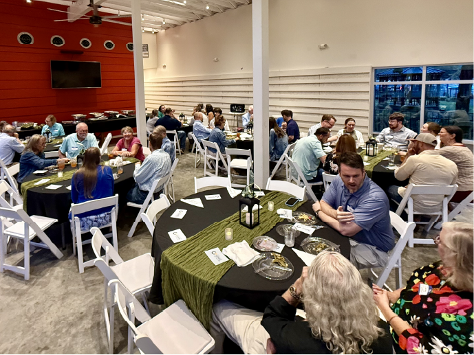 Northshore Gospel Network pastors and spouses seated at round tables having dinner in the Covington Firehouse Event Center