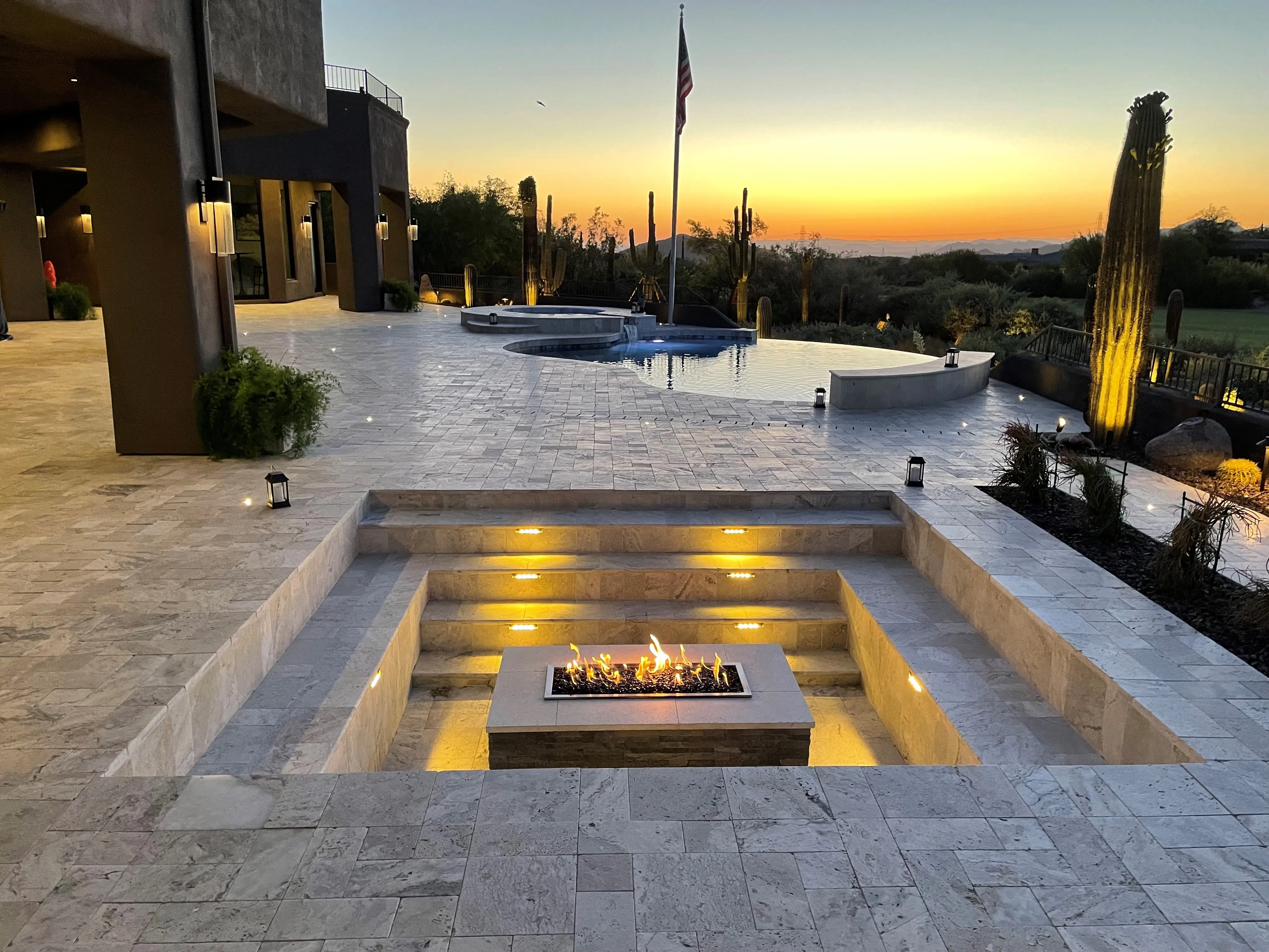 Sunken fire pit with step lighting and pool at sunset in Scottsdale desert estate