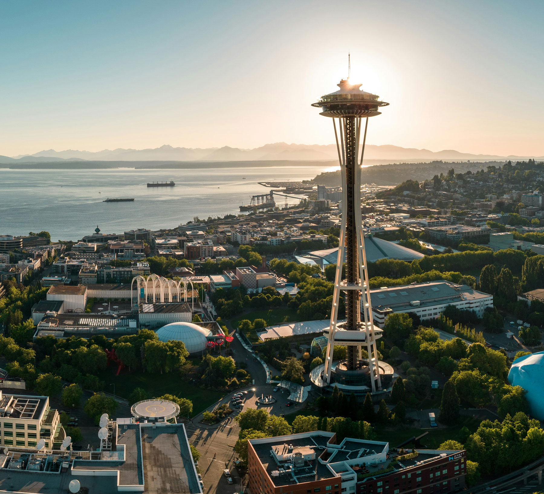 Aerial view of Seattle with the Space Needle tower and waterfront at sunset.