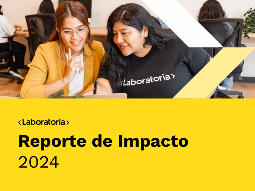 Dos mujeres sonrientes trabajando juntas frente a una computadora portátil, con un fondo amarillo que muestra el texto Informe de Impacto 2024.