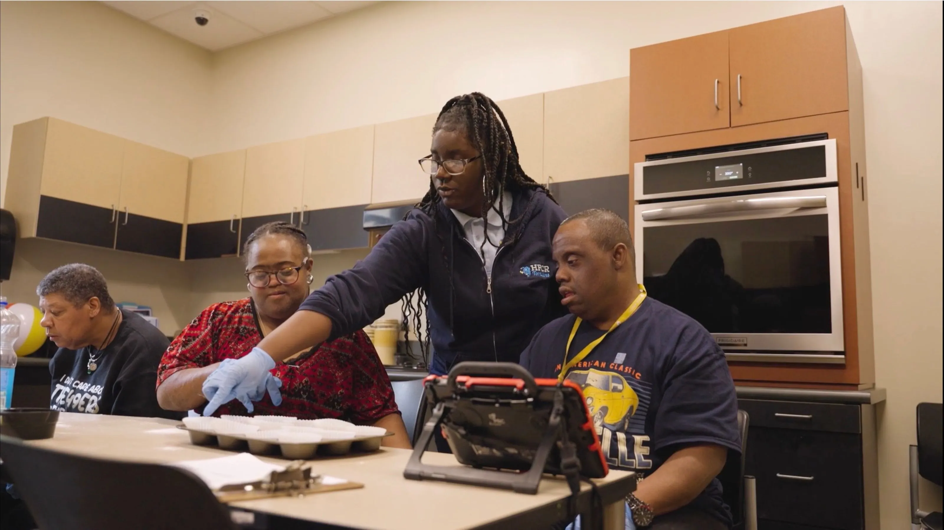 A Holy Family Cristo Rey student teaches a baking class for adults with intellectual disabilities at United Ability
