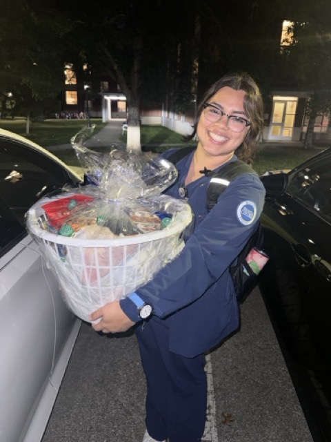 A graduate of Holy Family Cristo Rey holds a care package delivered to her college campus