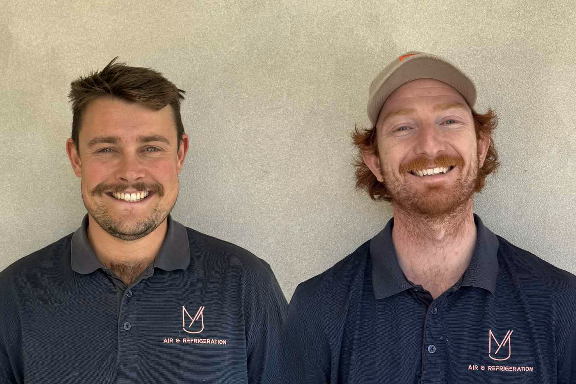 Two men smiling next to each other