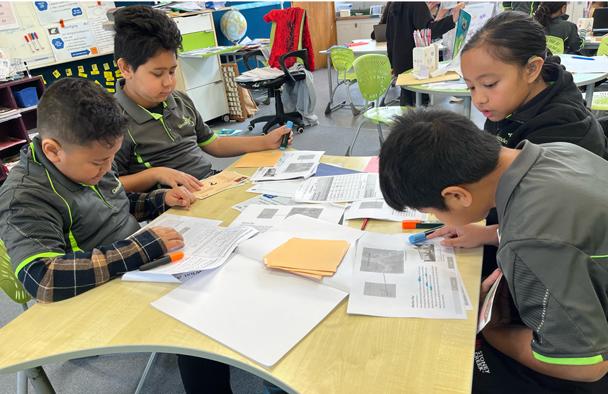Young Glendene school students work at a desk together.