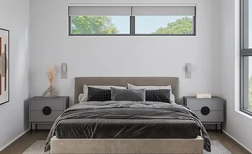 A bedroom with a large bed and two windows.