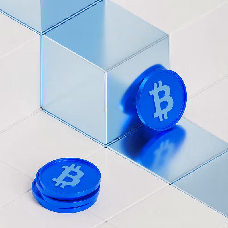 Pièces bleues avec symbole Bitcoin posées et appuyées sur un cube métallique brillant.