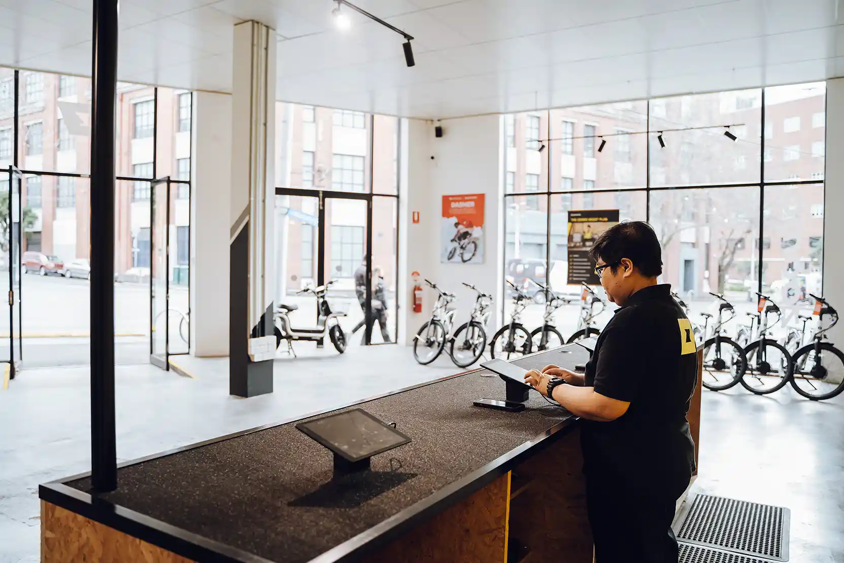 A person assisting a customer in a bike shop, with the heading "Customer Support."