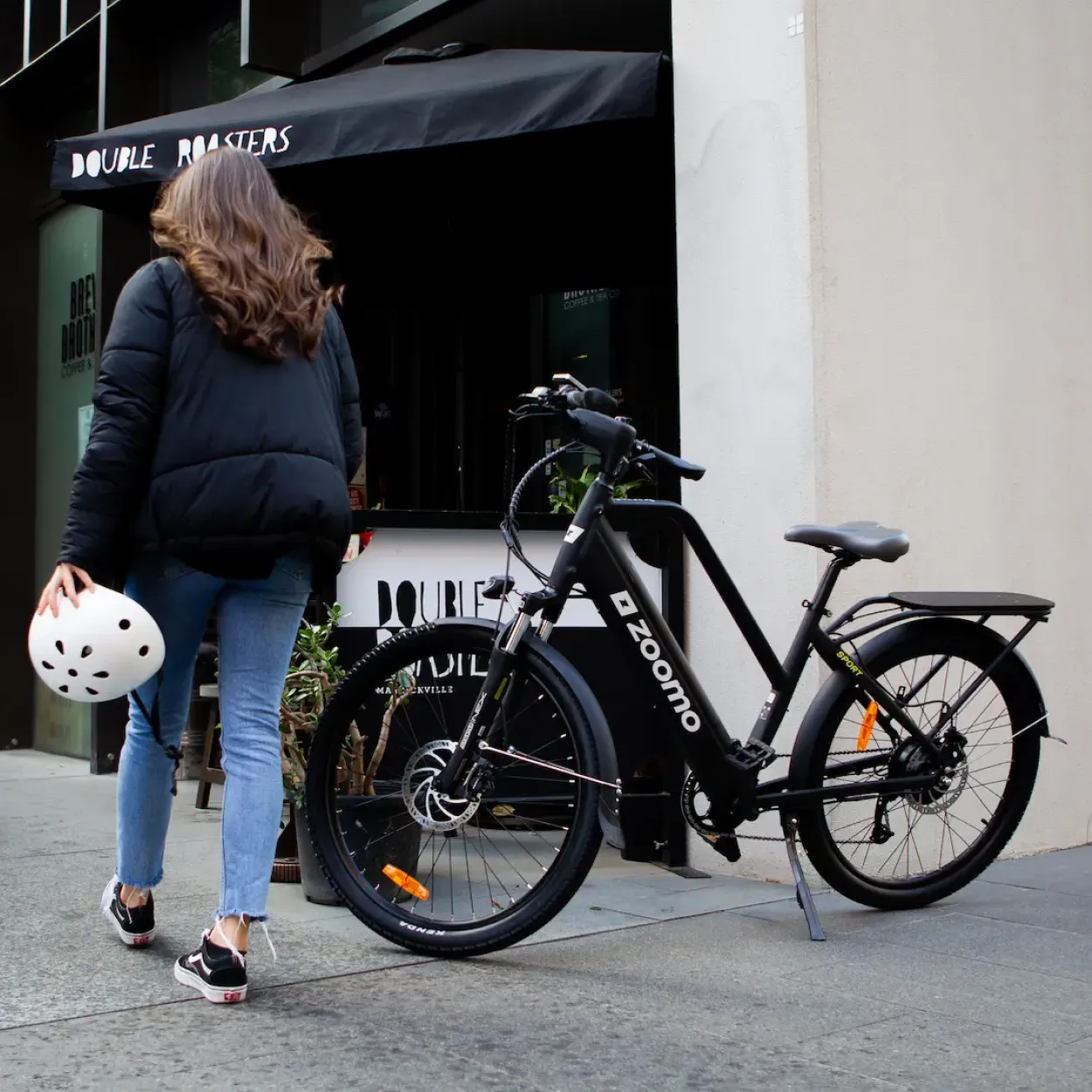 Person walking next to a Zoomo e-bike