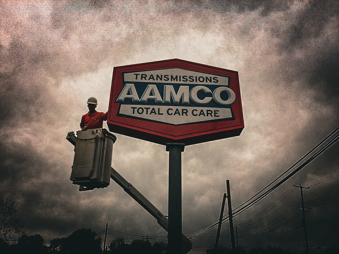 Martino Signs outdoor AAMCO Transmissions sign in Philadelphia, PA with worker
