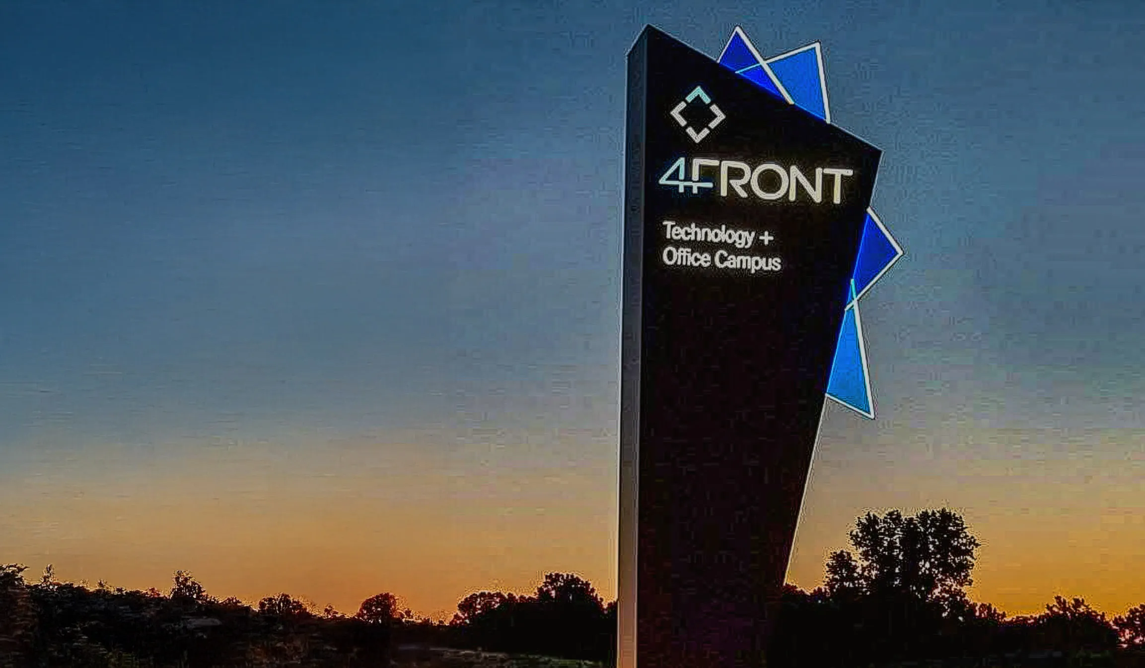 4Front Technology and Office Campus sign at sunset with blue geometric accents