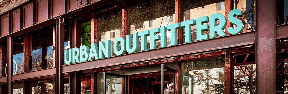Urban Outfitters storefront with large turquoise signage on rustic building exterior
