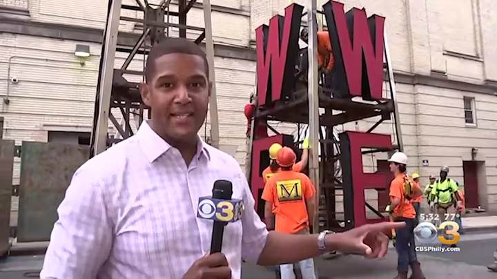 Martino Signs installs large exterior WWFE sign in Philadelphia with workers