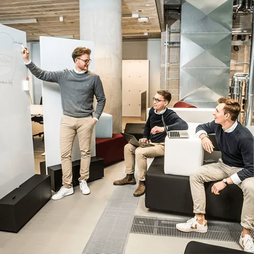 People in casual attire arranging items in modern office lounge area