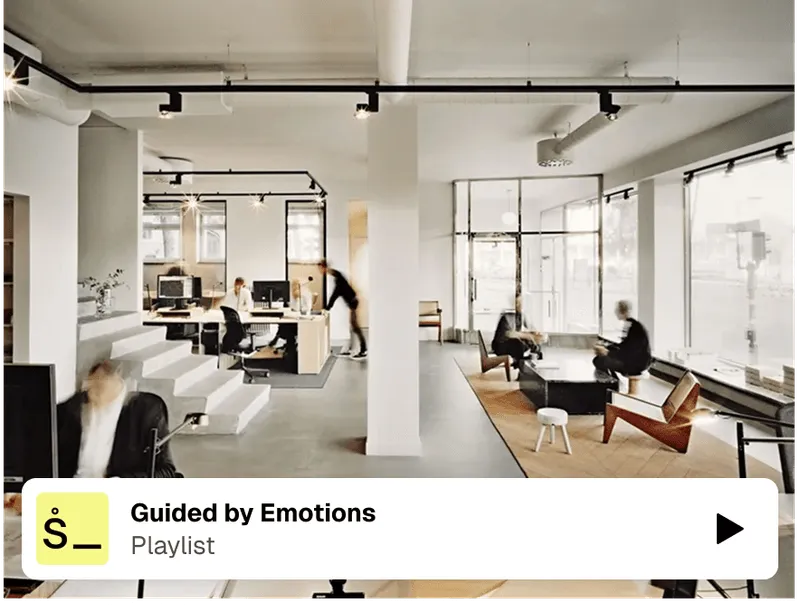 Modern office interior with "Guided by Emotions" playlist overlay