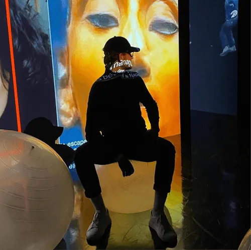 Person sitting against vibrant yellow artistic background