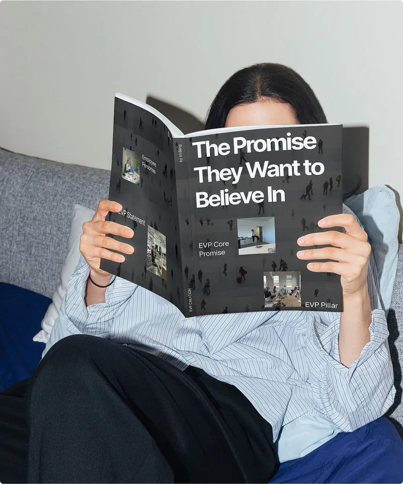 Person reading book titled 'The Promise They Want To Believe In' while relaxing in bed