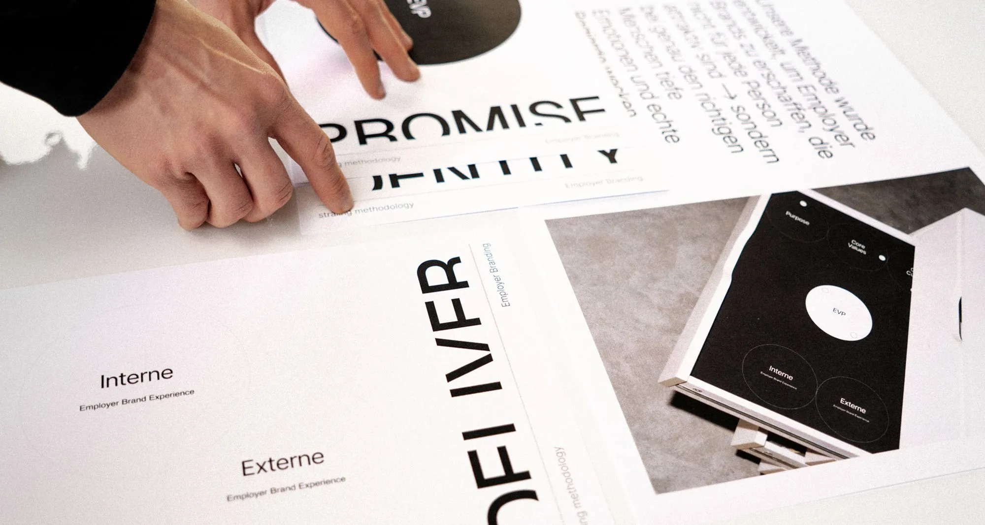 Hands arranging printed design materials