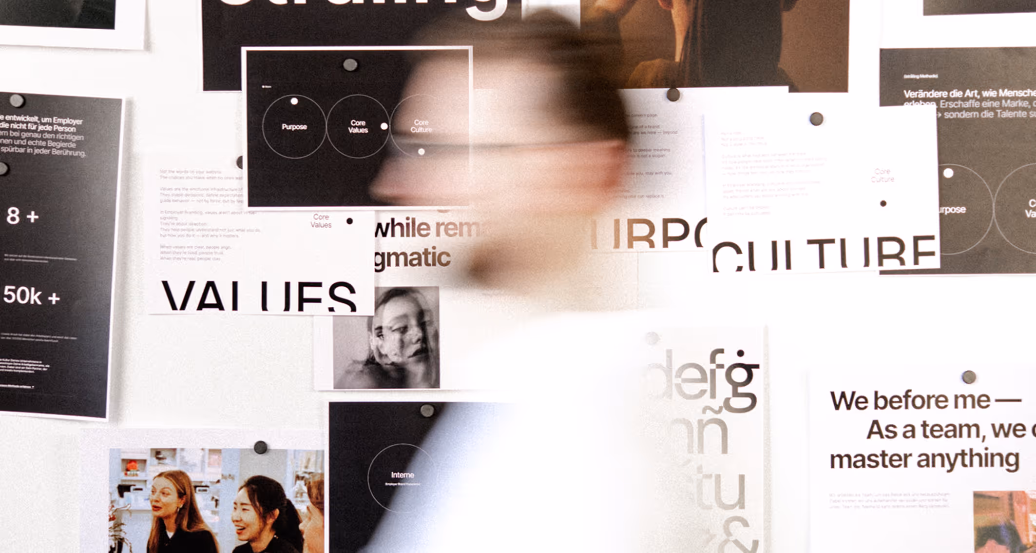 Blurred figure reviewing company values display board