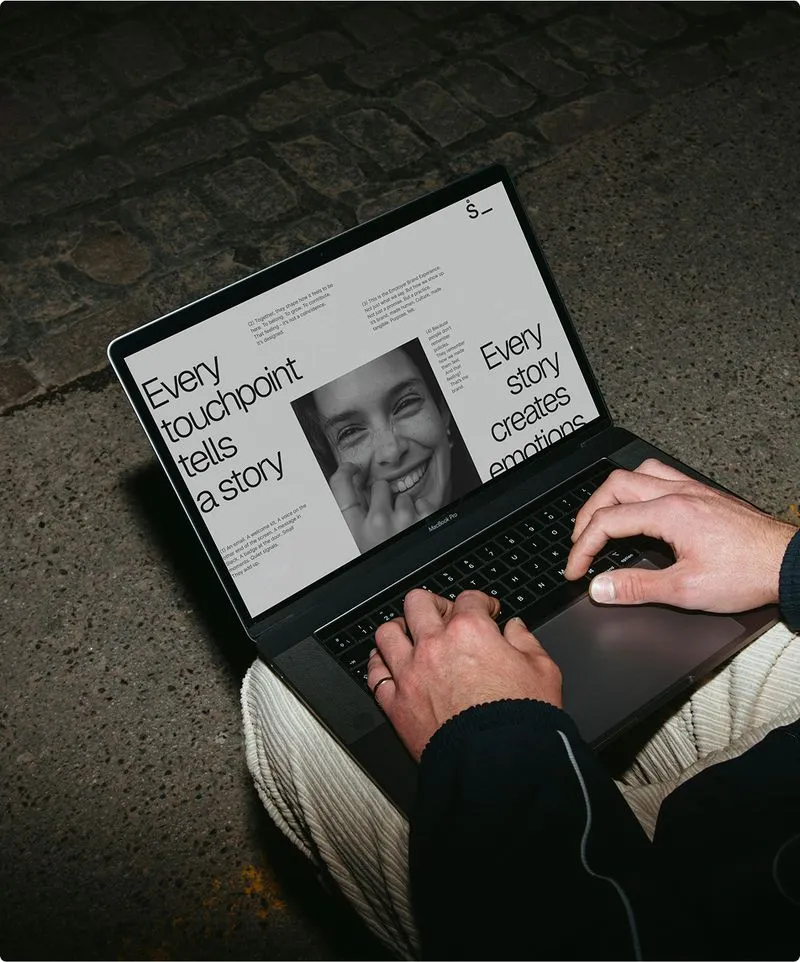 Hands typing on laptop keyboard with printed business materials