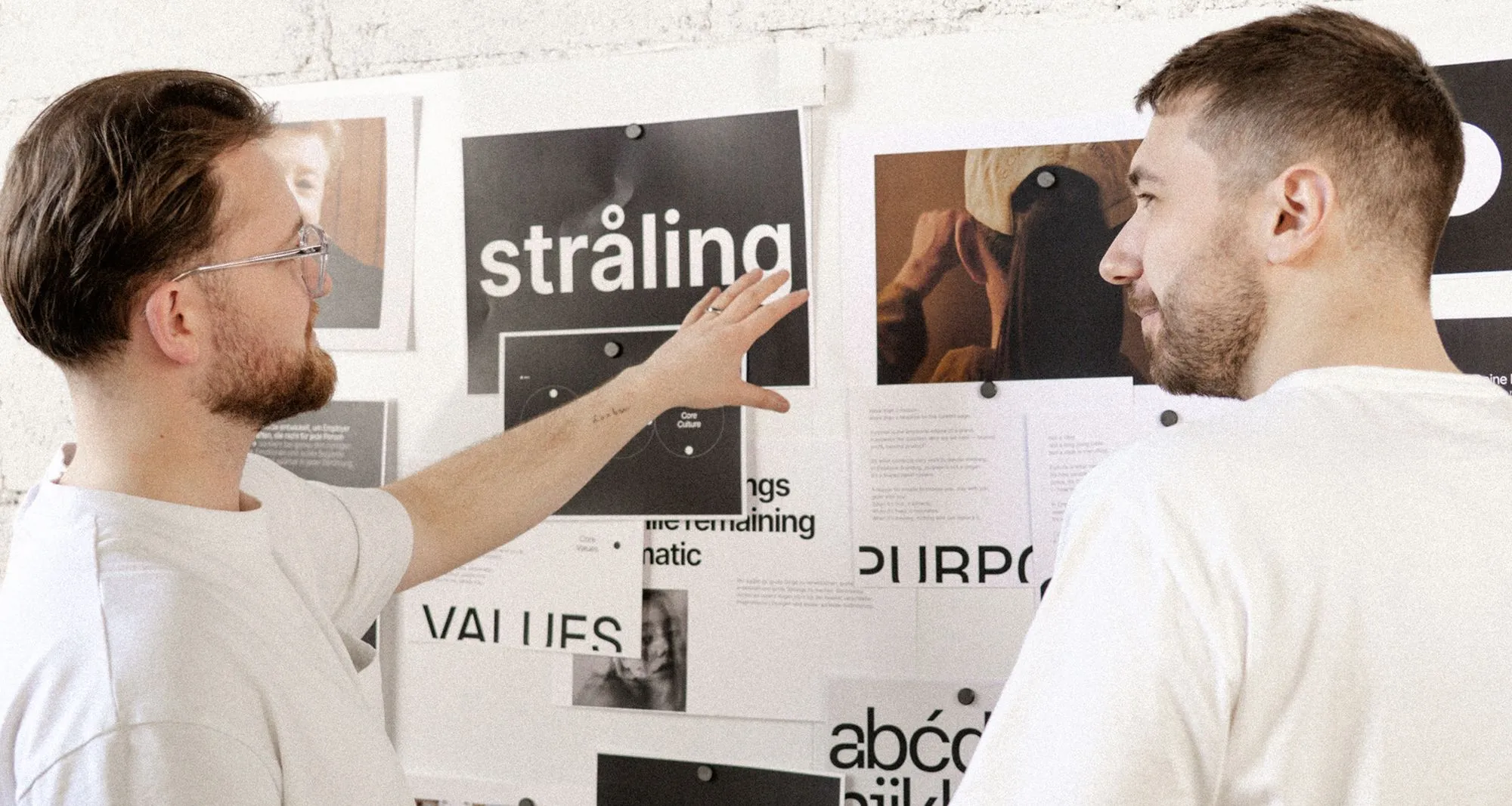Two people in white shirts discussing design materials
