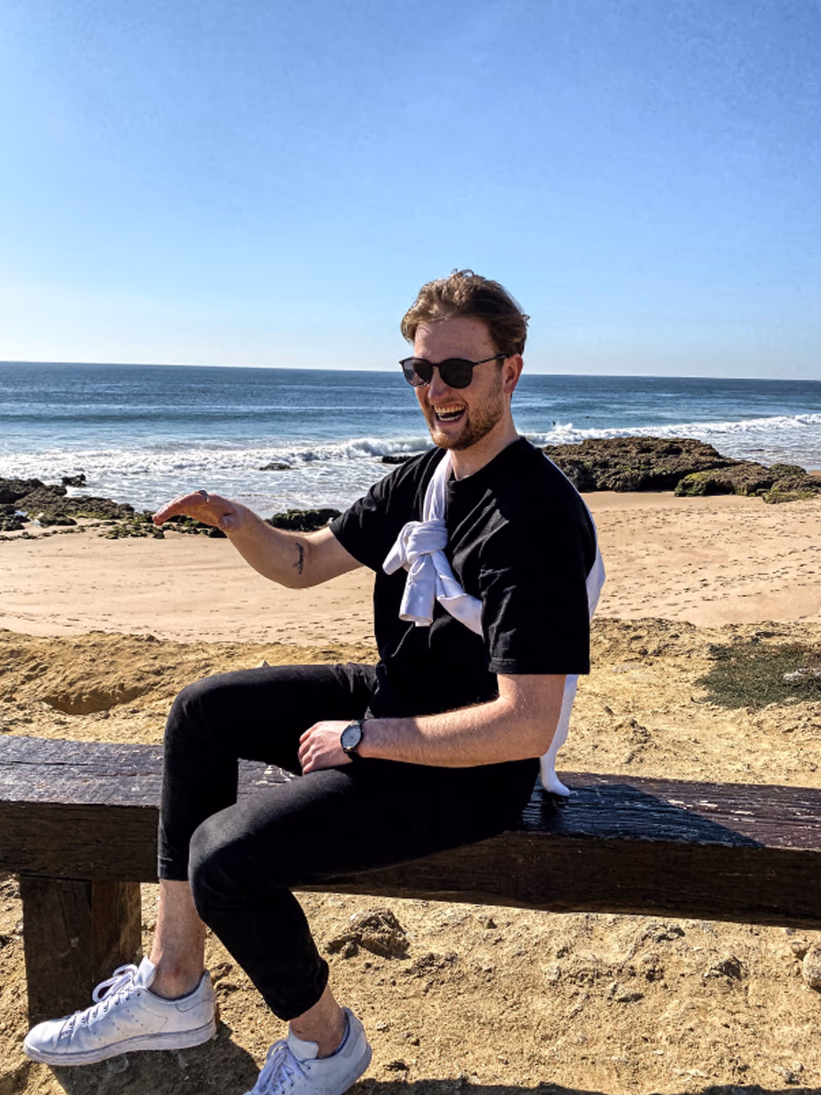 Person sitting on log at beach