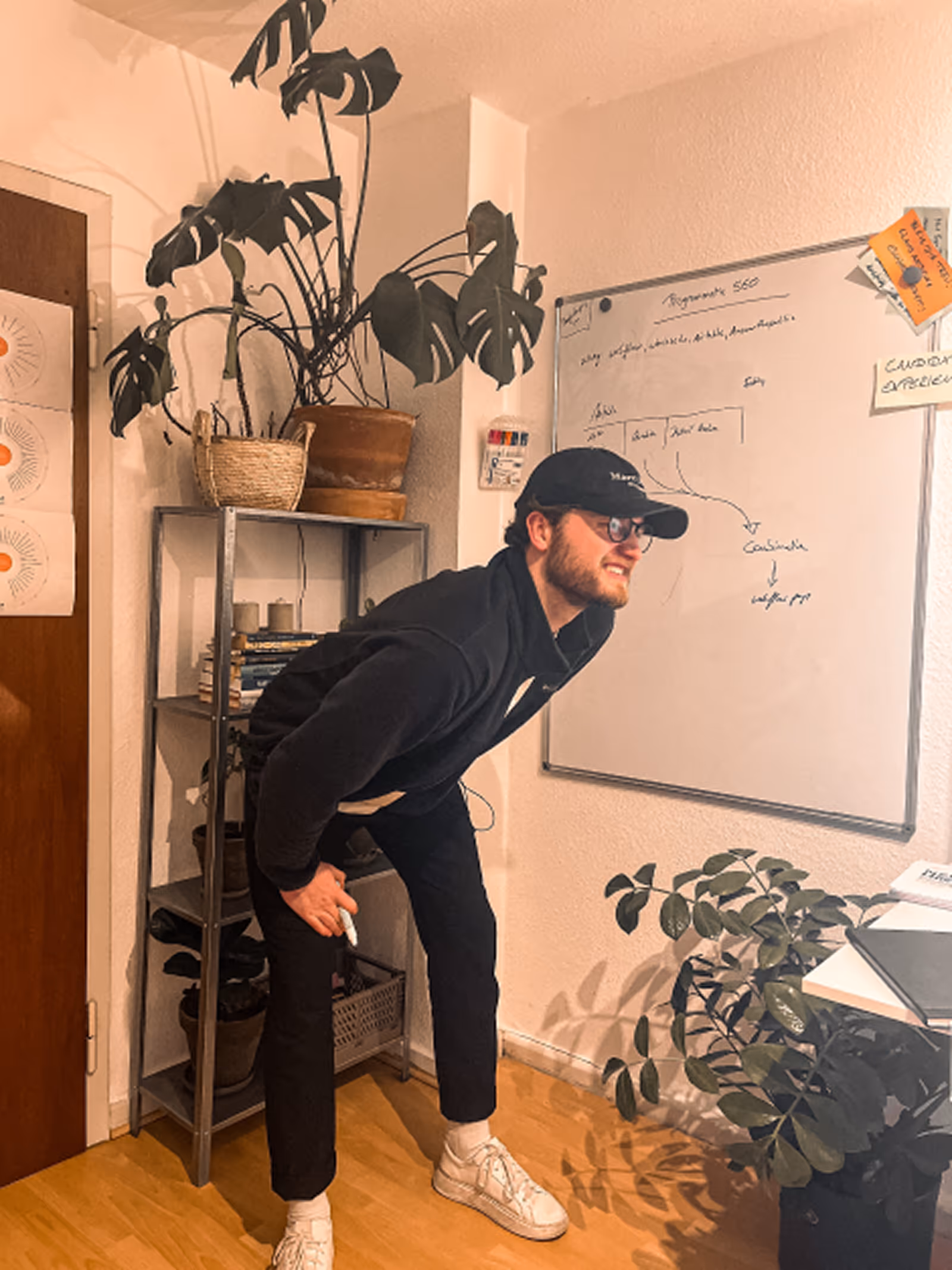 A person near plants is looking at a whiteboard