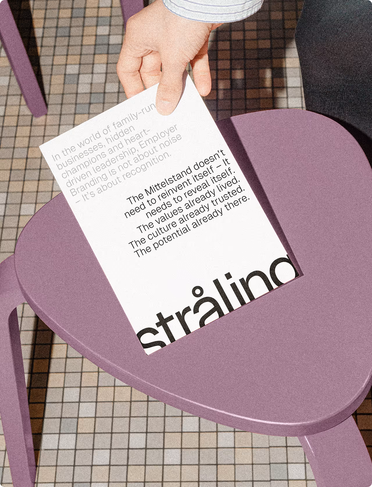 Hand holding document with 'straling' branding