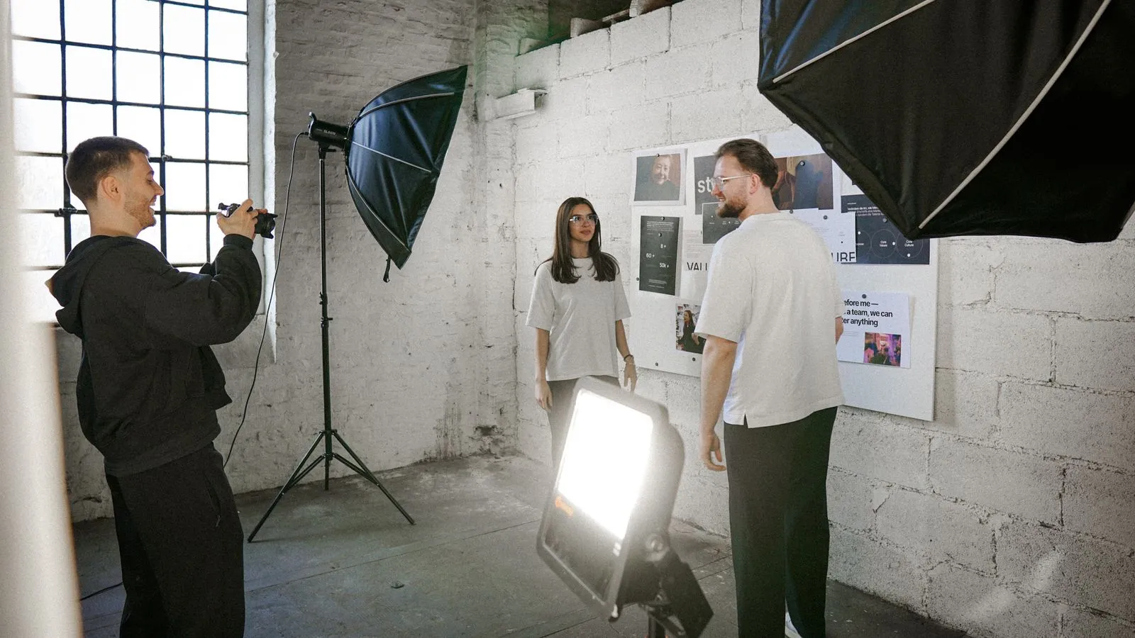 Three people in meeting discussing wall display