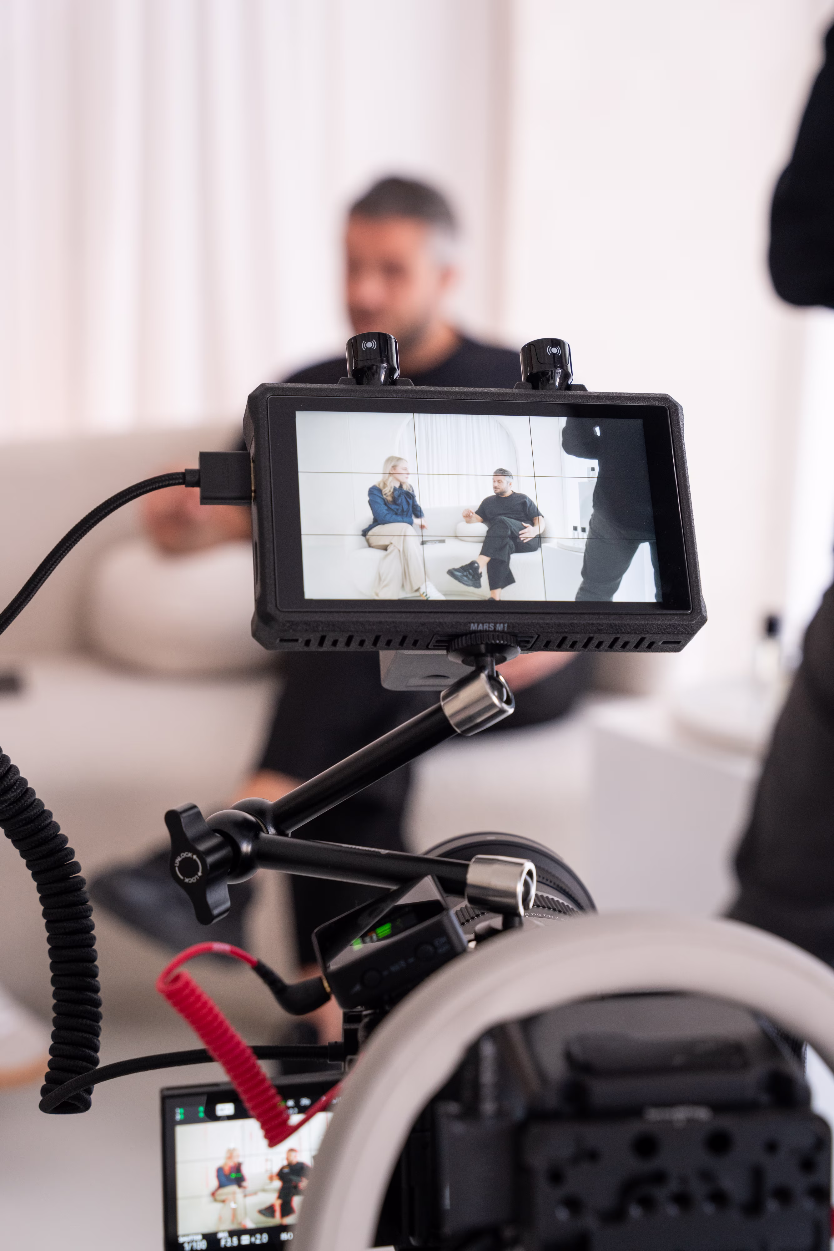 Ein Interview von einem Kunden von straling, einer Agentur für Employer Branding. Im Vordergrund eine Kamera, im Hintergrund Kunden der besten Employer Branding Agentur straling.