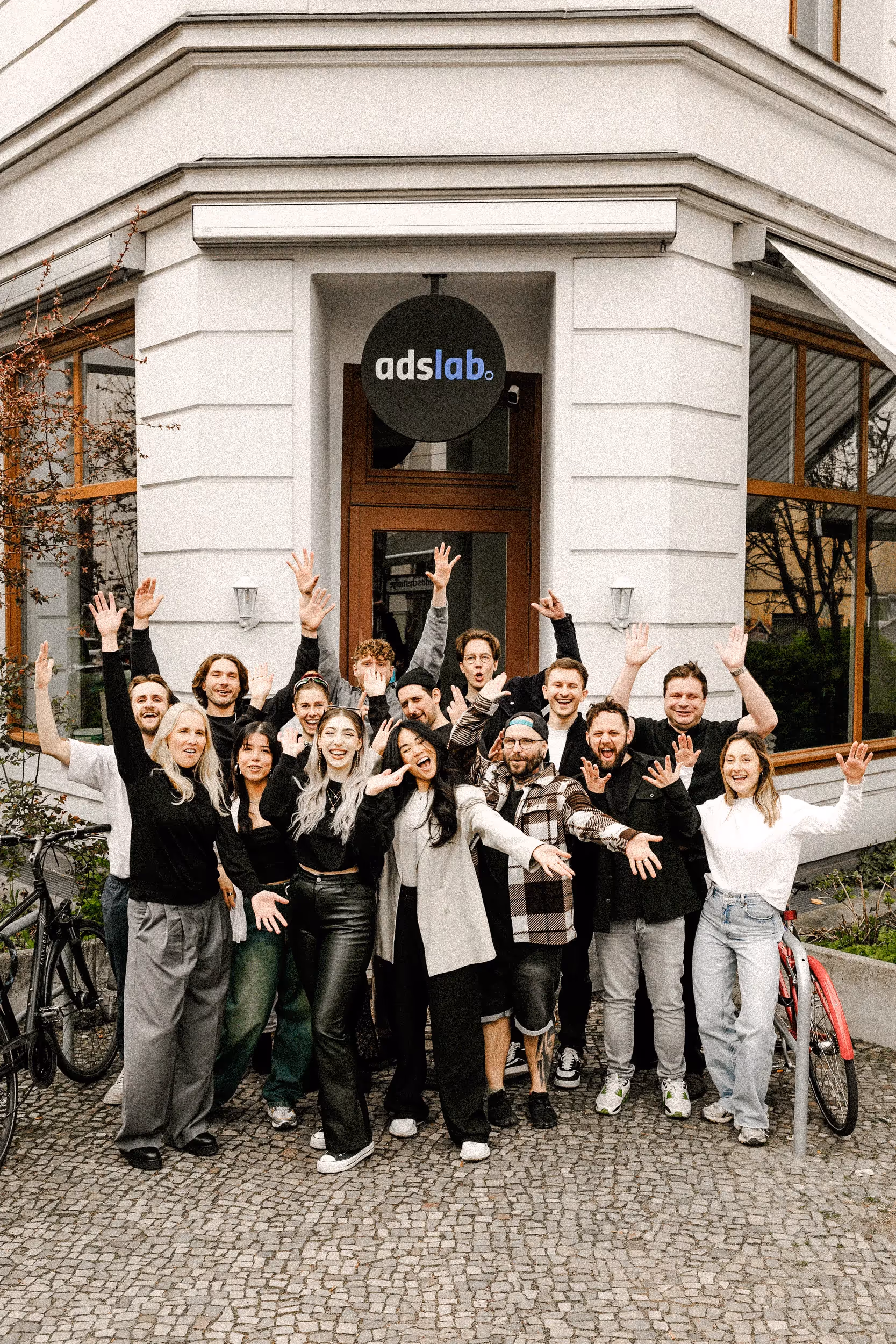 Das Team der Employer Branding Agentur stråling vor dem Bürogebäude – kreative Köpfe, die gemeinsam starke Arbeitgebermarken entwickeln.