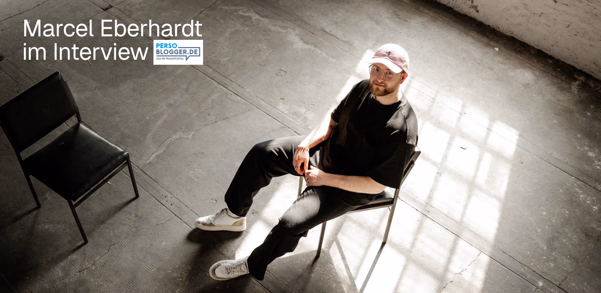 Marcel Eberhardt, Gründer der Employer Branding Agentur stråling, im Interview mit Persoblogger.de – Portrait vor Wand mit stråling Employer Branding Konzepten