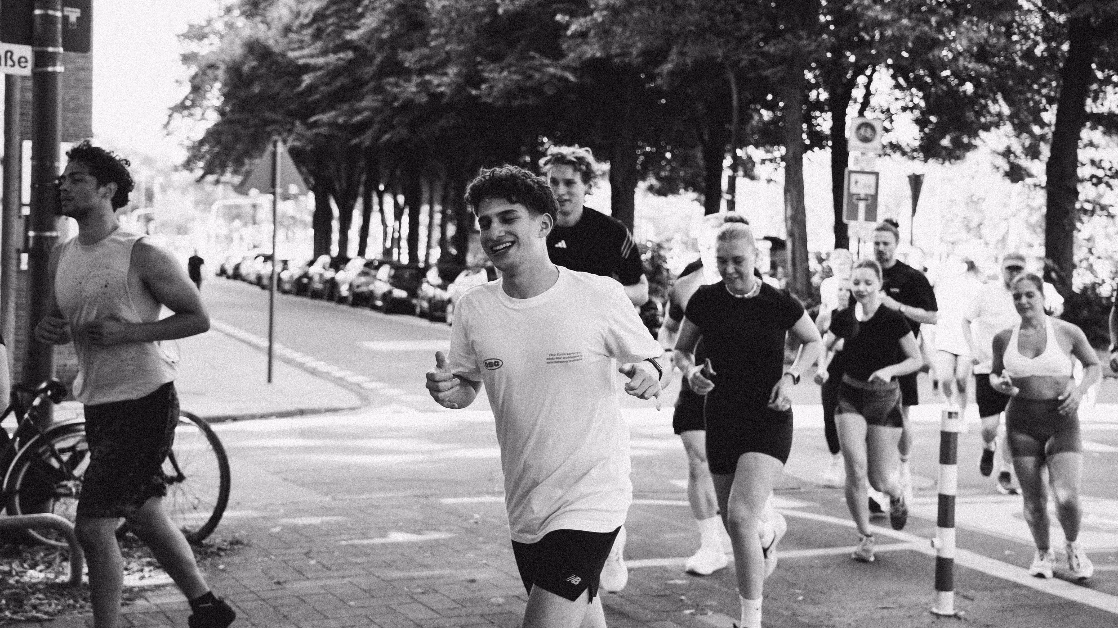 Mehrere Personen joggen als Gruppe durch den urbanen Raum, was den Team-Spirit und die Bedeutung von Community Building im Employer Branding visuell unterstreicht.