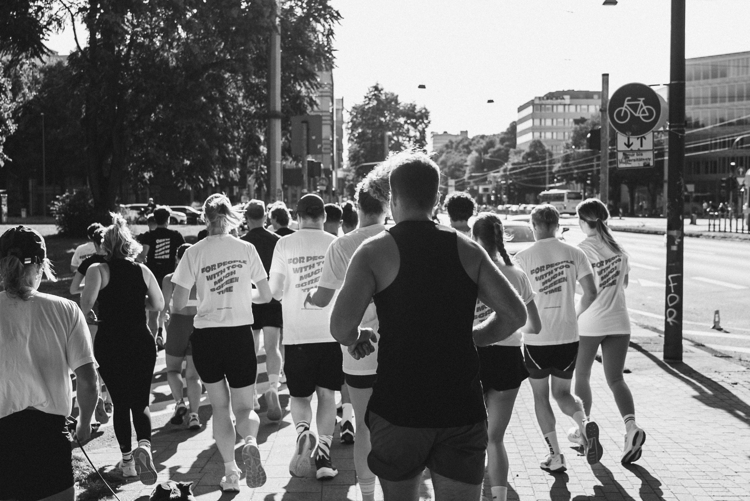 Eine Gruppe junger Menschen läuft gemeinsam durch die Stadt, lacht und interagiert miteinander – ein authentisches Beispiel für Employer Branding durch aktives Community Building.