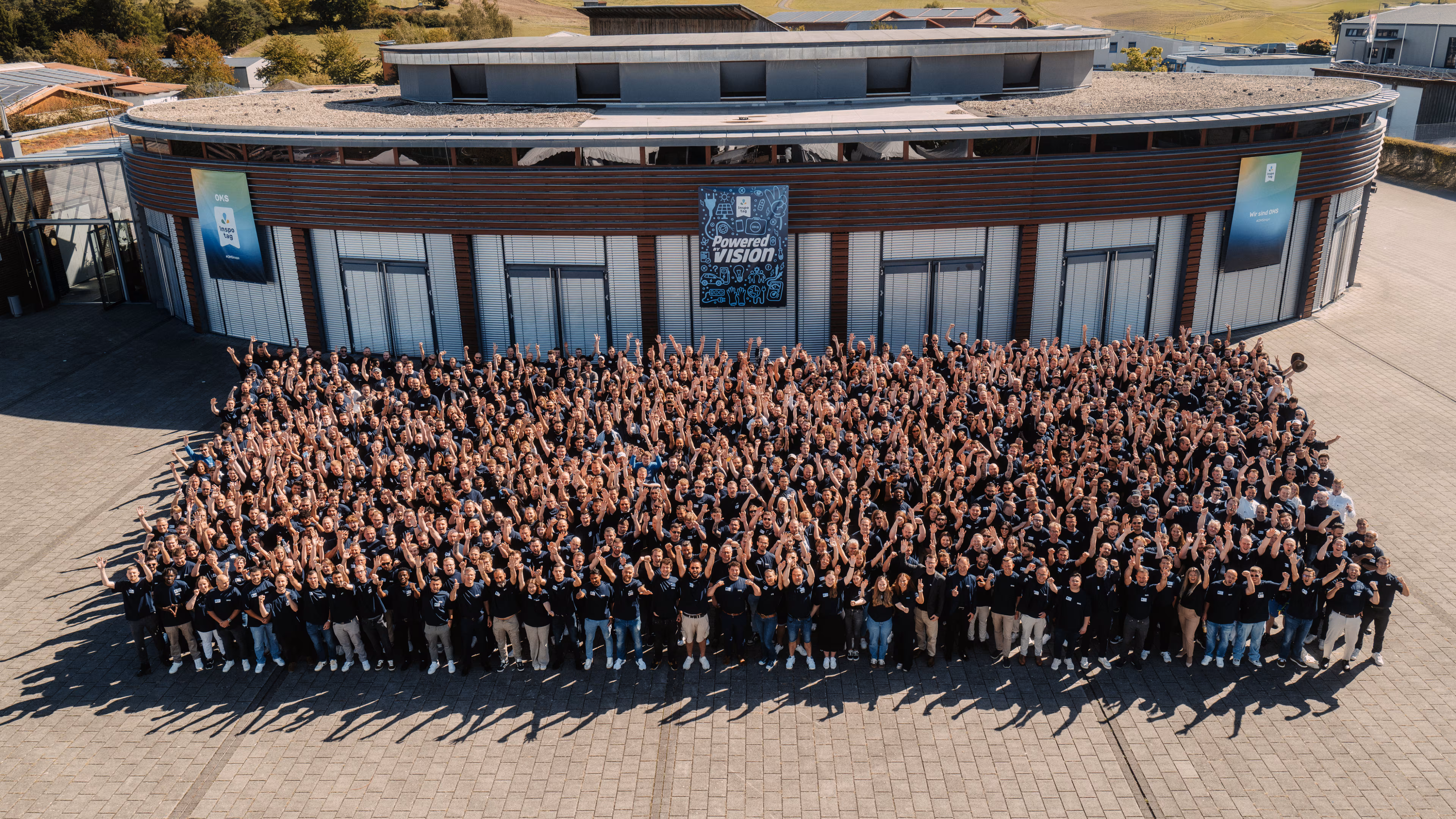 Ein Mitarbeiterbild von OMS Prüfservice am OMS Inspirationstag vor einer großen Halle