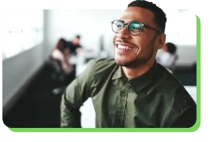 A man smiles off into the distance on a green background