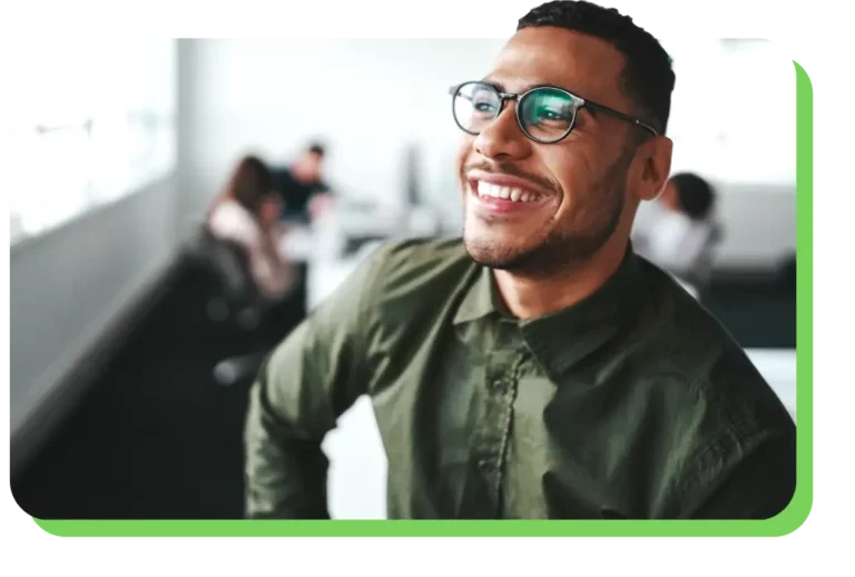 A man smiles off into the distance on a green background